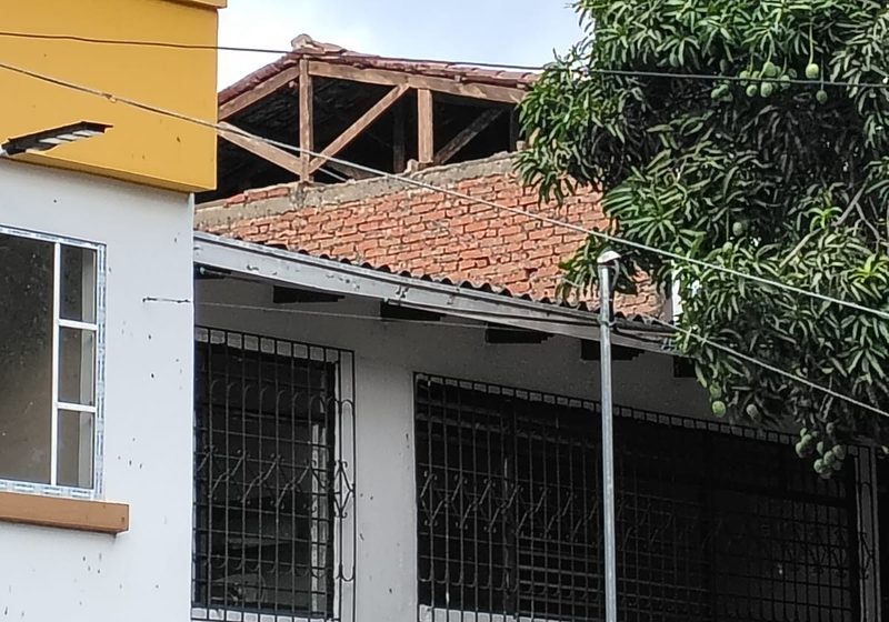 Culata desplomada y cubierta de madera expuesta en una vivienda de tres pisos del barrio La Alameda, Cali